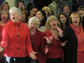 Singers from Crediton and Exeter University World Music Choirs entertain the crowds.